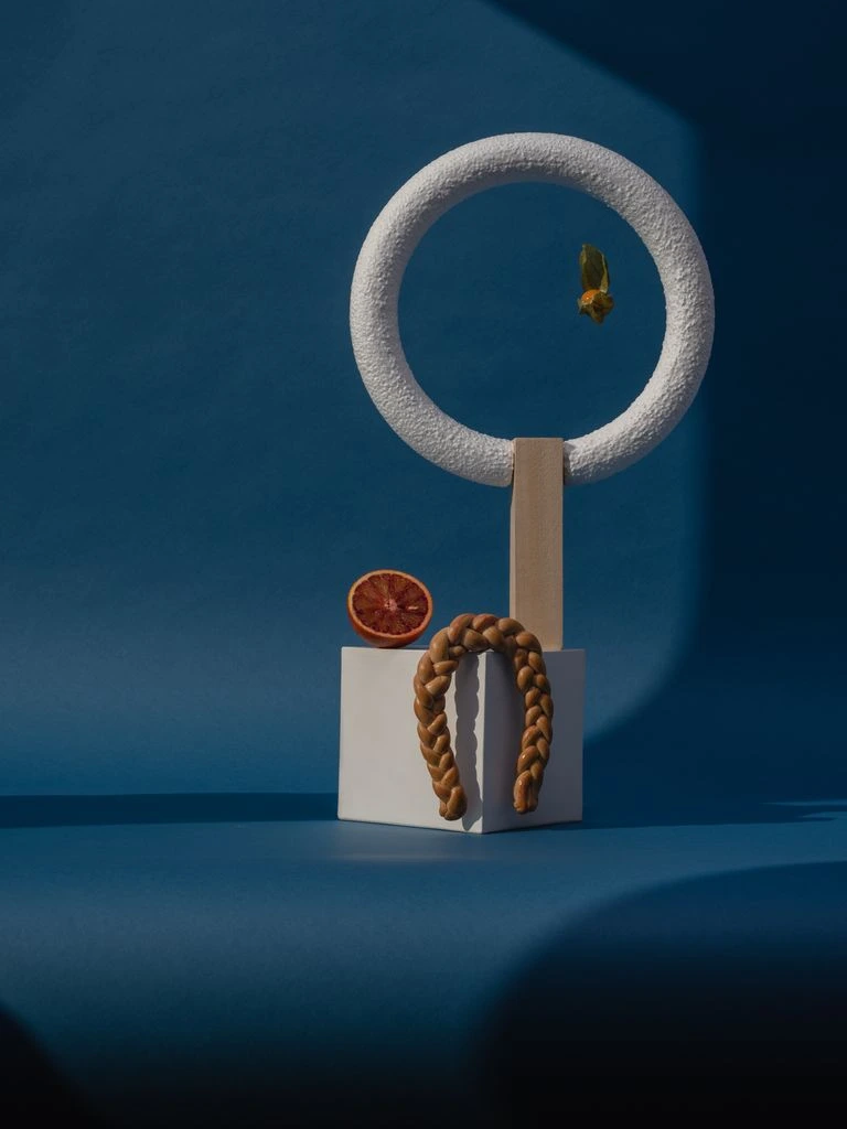 Forged brass crescent earring, No. 12 of 38, on cream linen